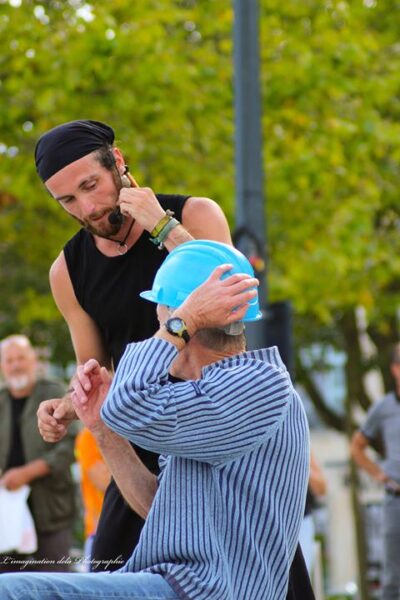 artiste de rue parlant à un volontaire dans sa langue